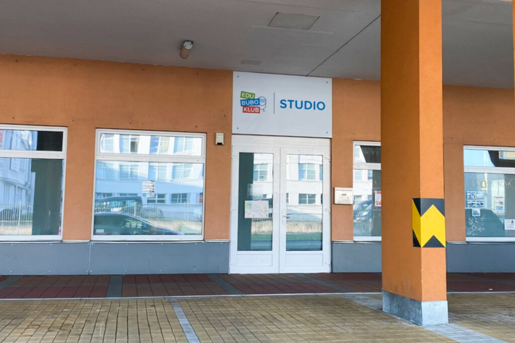 Vstup do studia Pohyb Nová Harfa - vstupní dveře, pohled z ulice, parkoviště